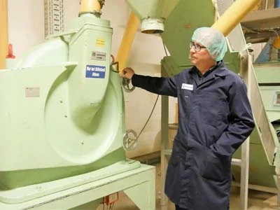 De heer Weber, staand naast een Hosokawa Alpine molen